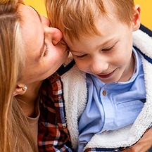 Mother kissing her young son on the cheek