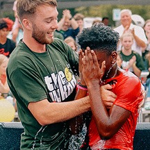Man comforting a young man during an emotional moment of faith