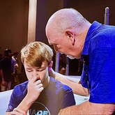 Dr. Marrow prays with a young boy during a baptism